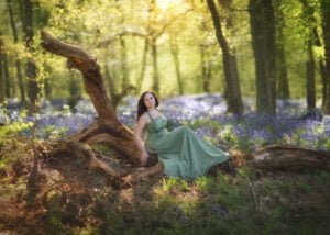 A woman in a flowing dress finds tranquility among the bluebells in Nottingham, a serene moment captured in a bluebell photoshoot.