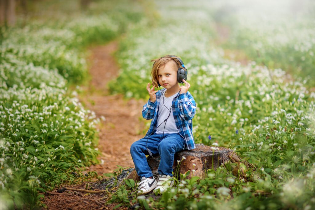 A child sits among a sea of wild garlic flowers in Nottingham, headphones on, lost in the magic of music and nature.