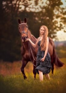 Woman walking with her horse during a countryside equine photoshoot