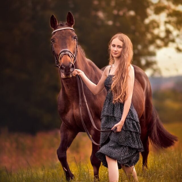 Woman walking with her horse during a countryside equine photoshoot