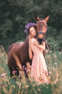 Woman embracing her horse during an intimate equine photoshoot in a meadow