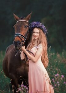 Woman with a lavender wreath standing beside her horse in a beautiful equine photoshoot
