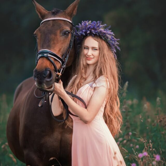 Woman with a lavender wreath standing beside her horse in a beautiful equine photoshoot
