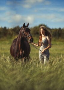 Woman in a field with her horse during an elegant equine photoshoot