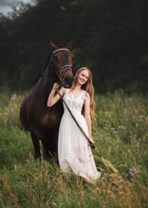 Smiling woman standing next to her horse during a horse photoshoot