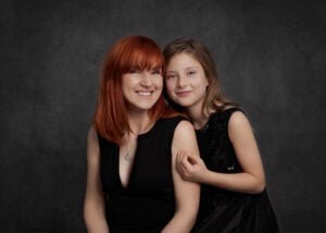 Smiling mother and daughter in black outfits during a studio photoshoot in Nottingham