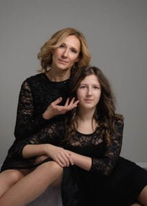 Mother and daughter posing together in a studio photoshoot with a modern background