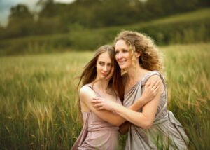Mother and daughter embracing in a field during a photoshoot in Nottingham.