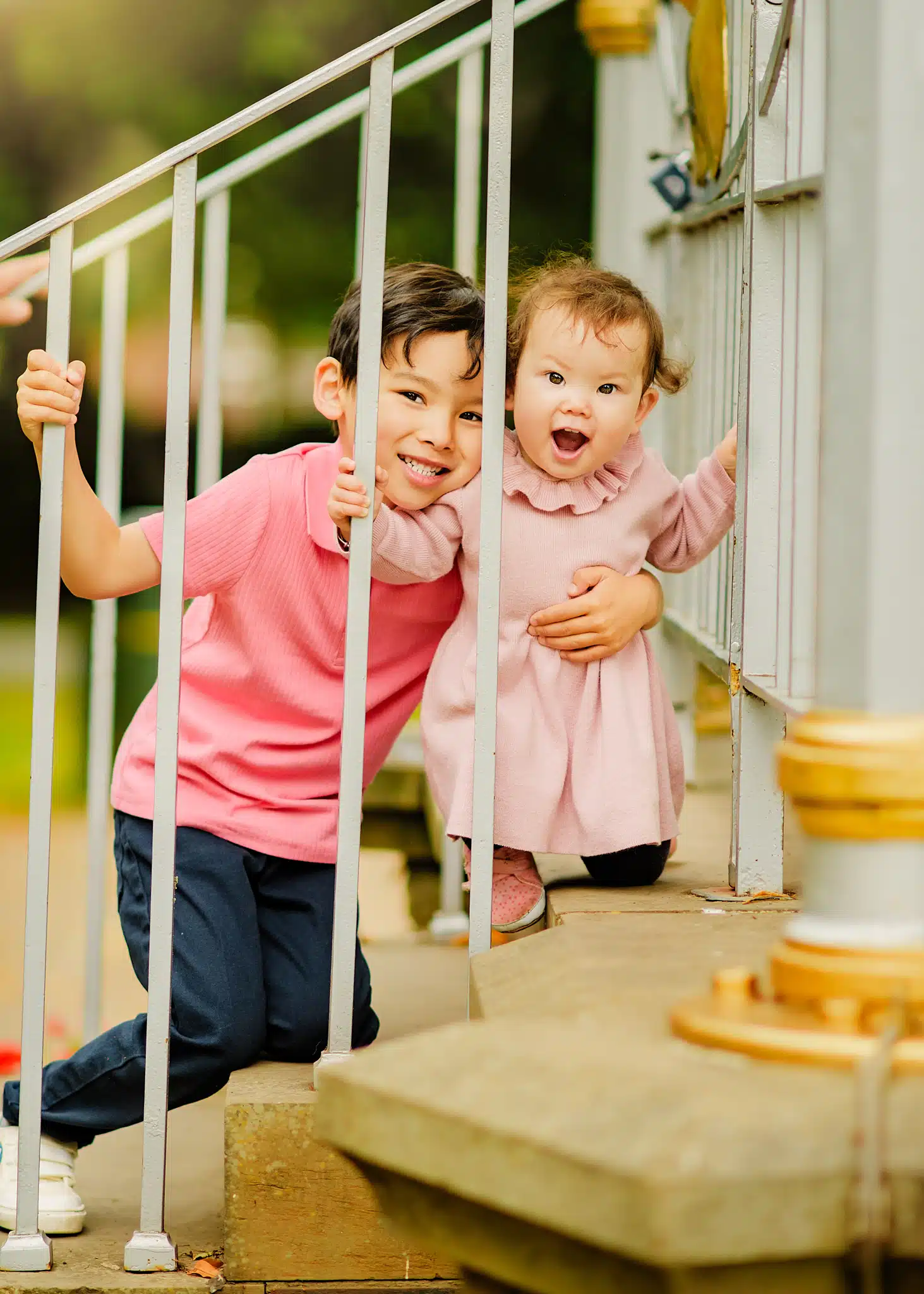 Two kids peeking through white railings during a fun photoshoot for kids in Nottingham.