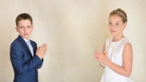Boy and girl in formal attire holding rosaries during their First Holy Communion Photography session in Nottingham.