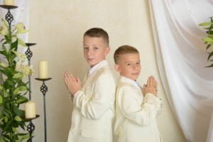 Two boys in white suits standing back-to-back during a First Holy Communion Photography session.