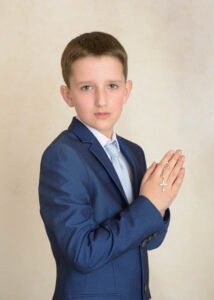 Boy in blue suit holding rosary during First Holy Communion Photography in Nottingham