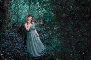 Professional woman portrait in a mystical green forest setting.