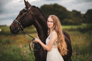 Woman with her horse in a field during a moody equine photoshoot