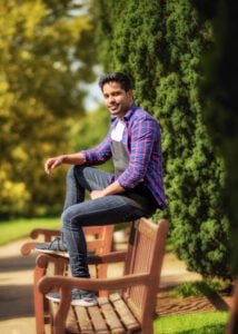 Man sitting on a bench in a Nottingham park during a friends photoshoot