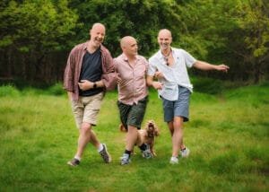 Three men walking with a dog in a Nottinghamshire field during a friends photoshoot