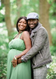 oyful expectant couple posing together in Nottingham forest during an outdoor maternity photoshoot.