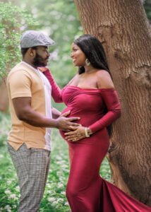 Expectant couple gazing at each other lovingly by a tree during their outdoor maternity photoshoot in Nottingham.