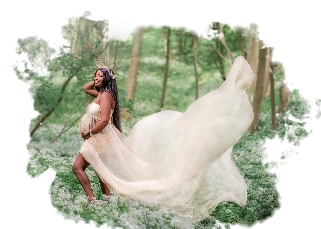 A radiant pregnant woman in a flowing dress stands amidst a forest blanketed in white flowers, her happiness as palpable as the spring around her.
