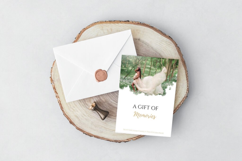 A tasteful gift voucher featuring an expectant mother in nature, titled 'A Gift of Memories' from Nottingham Family Photographer, presented on a wood slice with an envelope sealed with wax.