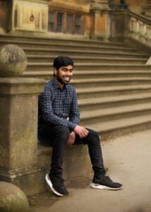 Man smiling on stone steps in Nottingham during a friends photoshoot