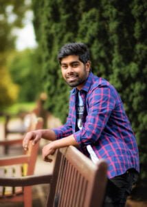 Man smiling and leaning on a park bench during a friends photoshoot in Nottinghamshire