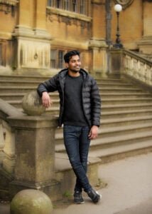 Man leaning on stone railing of a historic Nottingham building during a friends photoshoot
