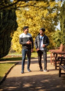 Two men walking together in a park during a best friends photoshoot in Nottingham