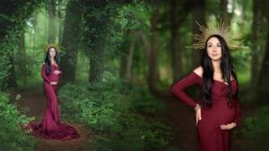 A pregnant mother in a burgundy gown surrounded by lush woodland during a baby bump photo shoot in Nottingham.