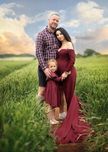Expecting parents and their daughter posing in coordinated outfits during a baby bump photo shoot in Nottingham.