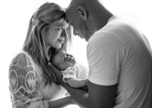 Parents gazing lovingly at their newborn baby during a natural lifestyle newborn photography session in Nottingham.