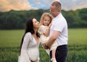 Family enjoying a moment of connection during a baby bump photo shoot in Nottingham’s countryside.