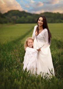 Pregnant mother and her daughter smiling during a baby bump photo shoot in Nottingham’s countryside