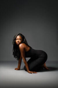 Vivacious at 40: A woman crouches in a powerful pose, her gaze fierce and captivating, marking a celebration of her strength and vitality.