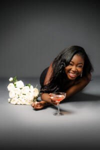 Exuberant Celebration at 40: A woman beams with joy, her laughter echoing the happiness of a milestone birthday, accented by white roses and a festive cocktail.