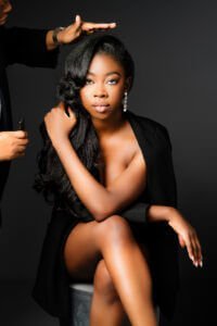 Woman in a black outfit getting her hair styled for an elegant birthday photoshoot in Nottingham studio.