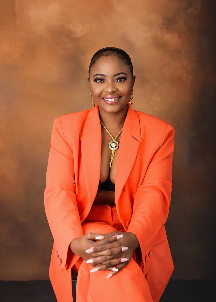Woman in a vibrant orange suit posing confidently during a professional birthday photoshoot in Nottingham studio.