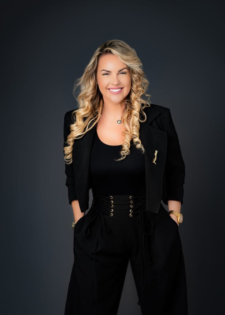Smiling professional businesswoman in formal black attire during a polished professional business photoshoot for branding and corporate profiles.