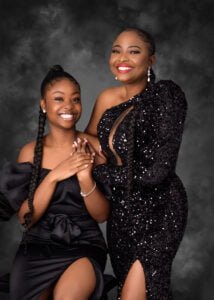 Mother and daughter in elegant black dresses celebrating a heartfelt birthday photoshoot in Nottingham studio.