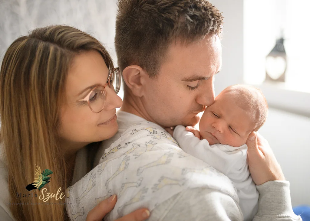 Parents lovingly embracing their newborn baby during a lifestyle newborn photoshoot at home.