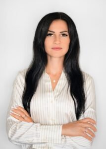 Professional headshot of a businesswoman in formal attire with crossed arms during a professional business photoshoot.