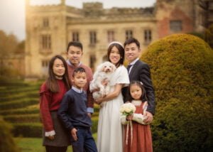 Family posing with the couple and their dog during a pre-wedding photoshoot at Elvaston Castle gardens.
