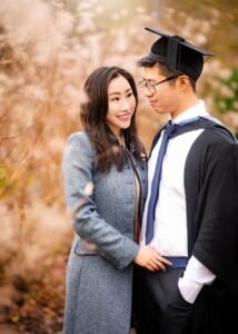 Male graduate in cap and gown with his mother on Nottingham University campus