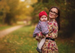 Mother holding her smiling baby during a family outdoor photography session in Nottingham.