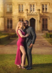 Engaged couple posing elegantly in front of a historic building during their engagement photoshoot.