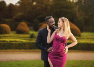 Engaged couple sharing a loving moment in a beautifully landscaped garden during their engagement photoshoot.