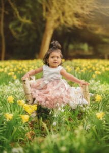 A child seated among vibrant yellow daffodils during a Mother and Child Photoshoot in Nottingham.