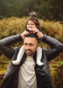 A father shares a playful moment with his baby during a family photoshoot in Nottingham.