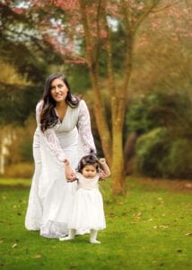 A mother guiding her toddler during a Mother and Child Photoshoot in Nottingham’s lush green park.