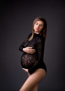 Expectant mother in a patterned black bodysuit during a maternity photoshoot in Nottingham studio.